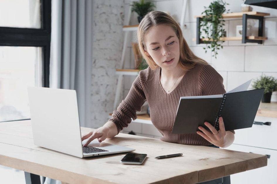 Evaluating Workflow App Consolidation Trade-offs Person reviewing a productivity setup and checklist before consolidating applications.